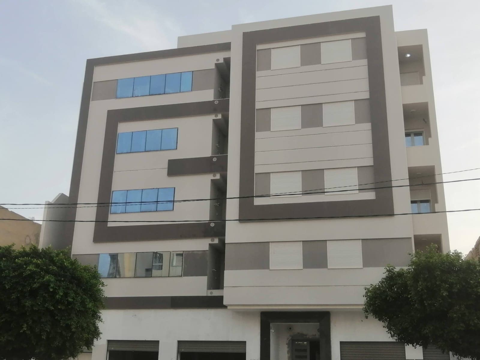 Façade aux tons clairs encadrée de gris