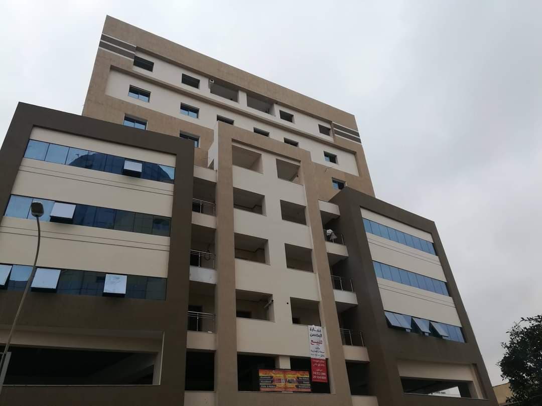 Façade beige rythmée par de larges cadres bruns
